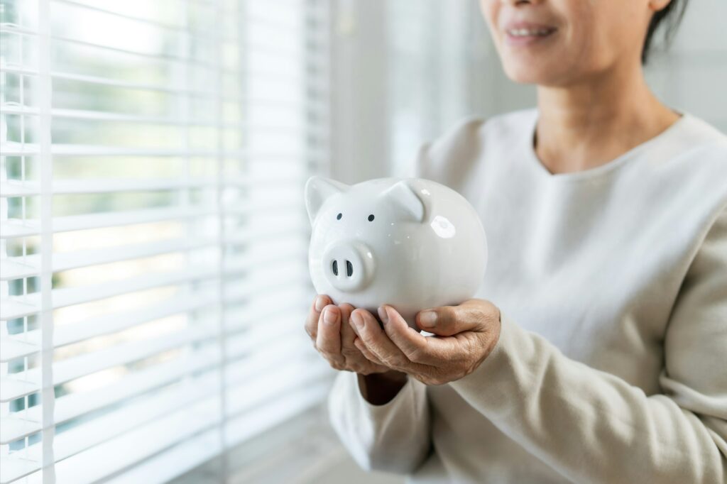Mother's hand holding a piggy bank Concept of saving money or financial investment