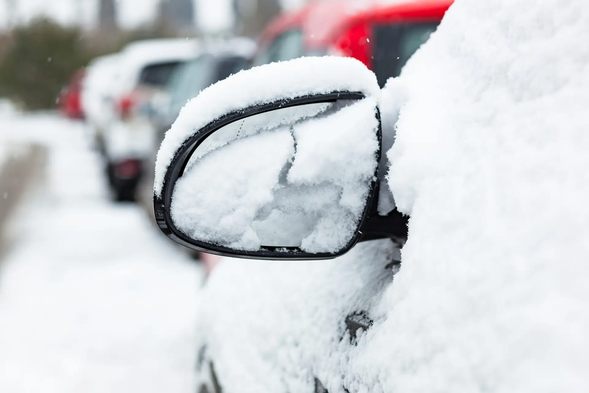 Rearview mirror covered with snow. Transport after snowfall.